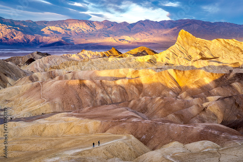 Hikers on the slopes of Zabriskie Point at sunrise in Death Valley National Park in California, United States