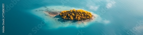 aerial shot of a small autumn-colored island in a serene blue lake
