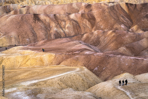 Hikers on the slopes of Zabriskie Point at sunrise in Death Valley National Park in California, United States