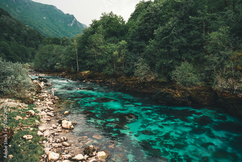 The turquoise color of the Piva River before the dam is released, crystal clear drinkable water surrounded by green mountains and granite rocks photo