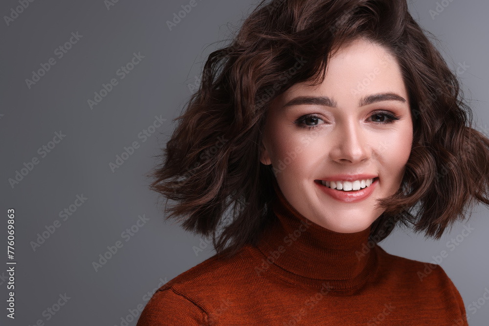Portrait of beautiful young woman with wavy hairstyle on grey background. Space for text Portrait of beautiful young woman with wavy hairstyle on grey background. Space for text