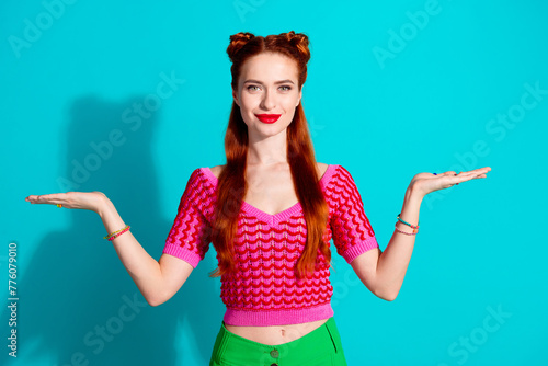 Photo of funky cute lady dressed pink knitted shirt comparing arms emtpy space isolated blue color background