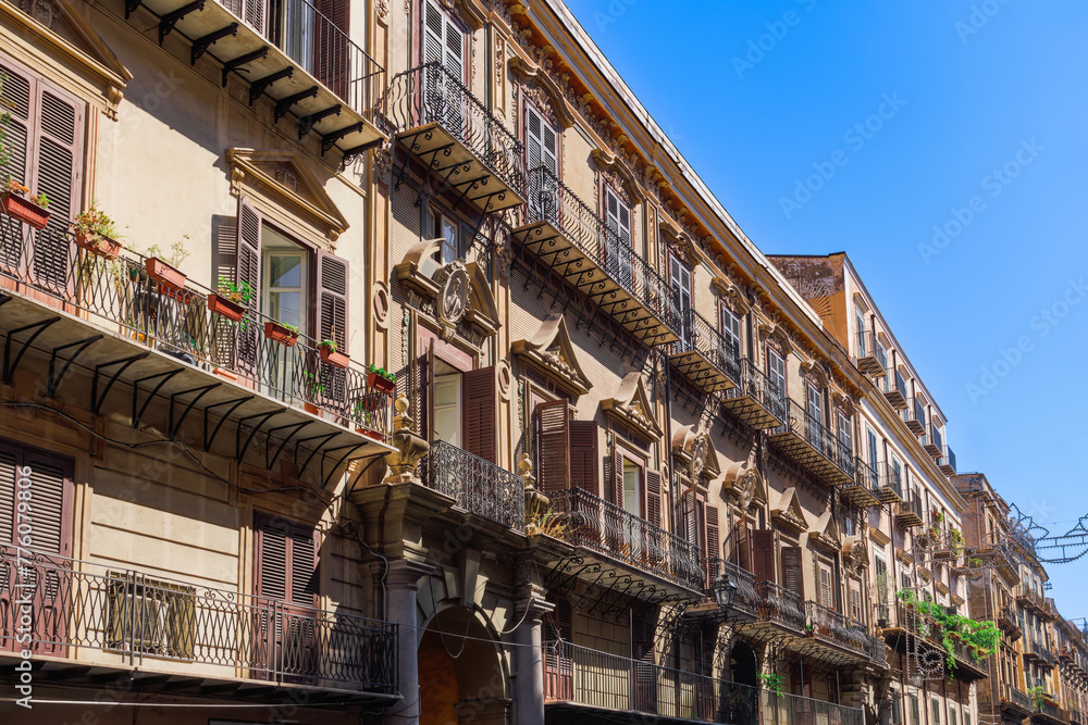 Palermo Via Vittorio Emanuele traditional architecture houses with iron balconies and wooden window shutters facade in Sicily, Italy.