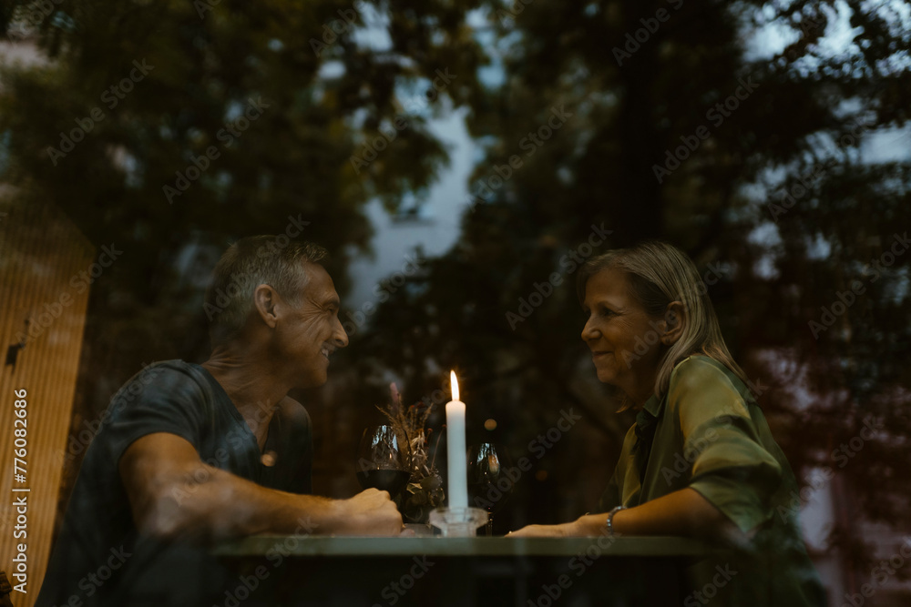 Low angle view of mature couple enjoying candlelight dinner at restaurant Low angle view of mature couple enjoying candlelight dinner at restaurant