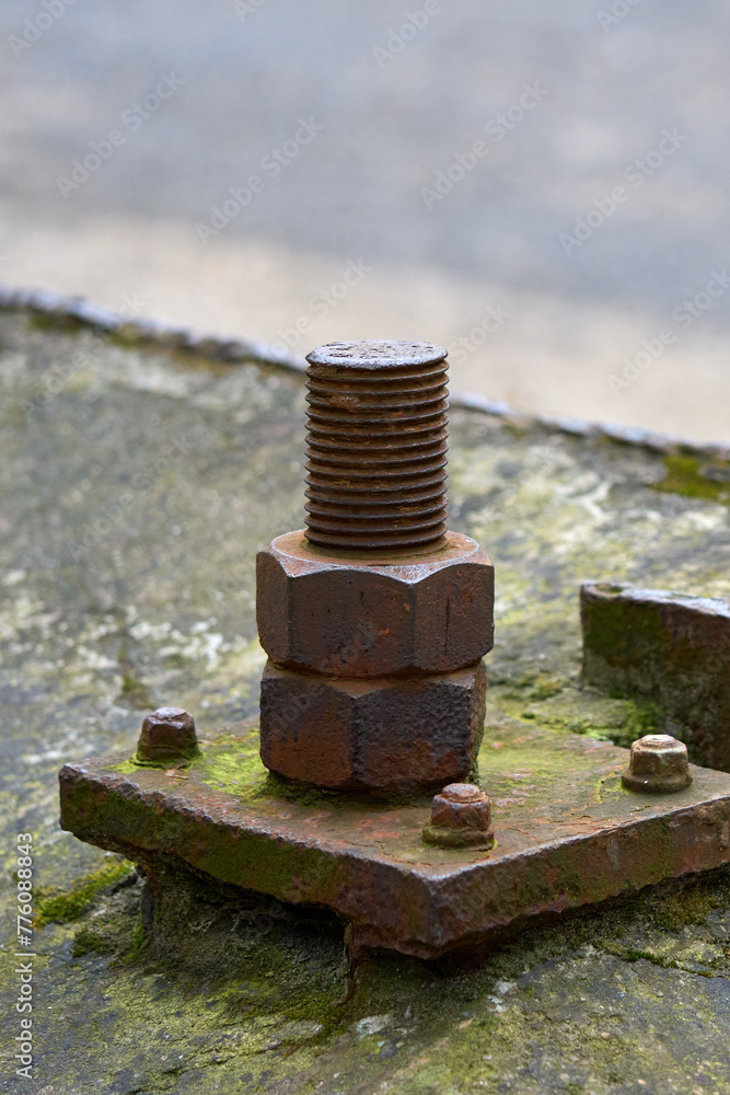 An old rusted bolt and nut hold together a metal structure. An old rusted bolt and nut hold together a metal structure.