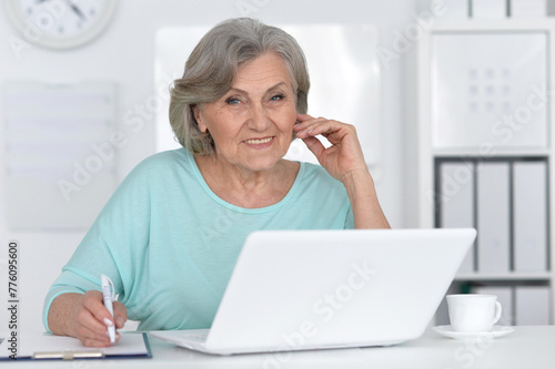 Senior business woman working in office with laptop