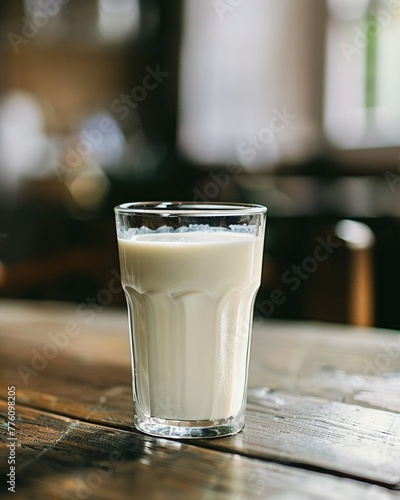 A fresh, non homogenized glass of milk prominently displaying a rich, creamy top layer, indicative of high quality, ecofriendly dairy farming practices photo