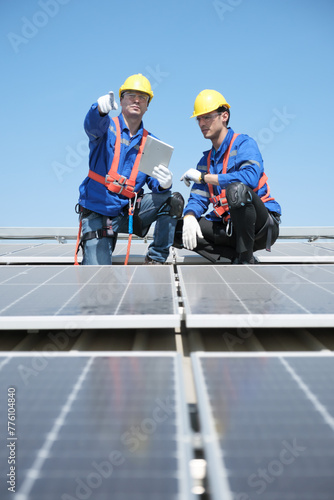 Engineers or workers install and inspect solar cell on the roof of the factory.