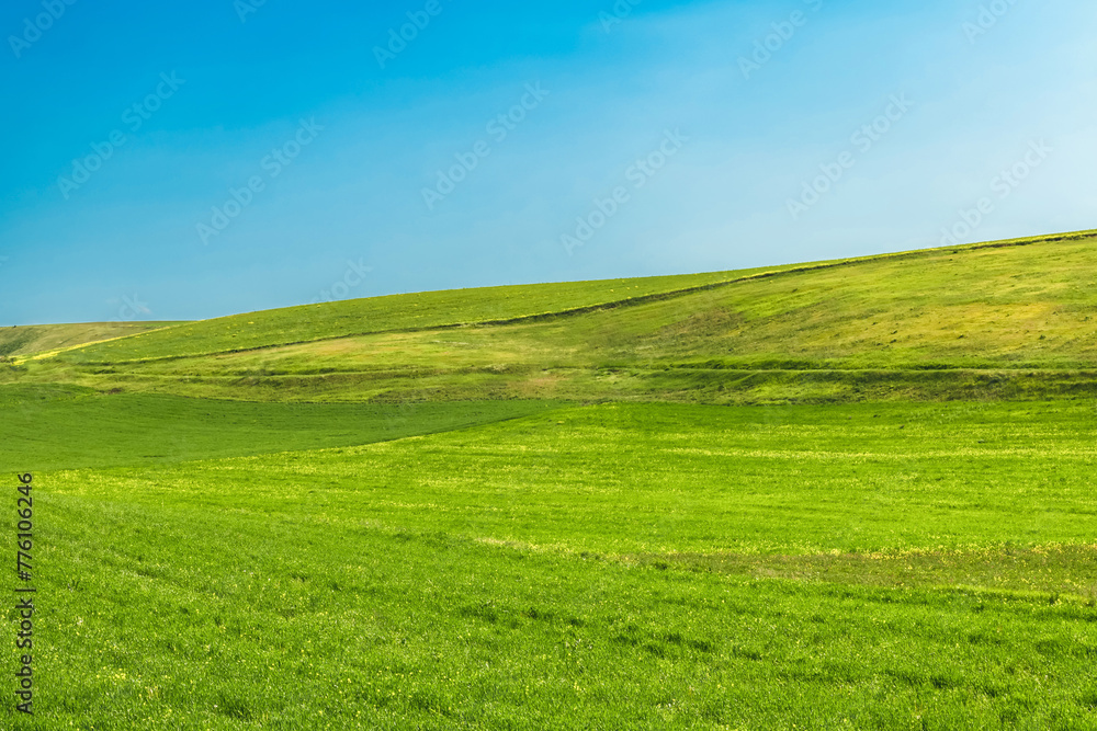 Green hills and blue sky. Spring green grass. Summer travel. Natural spring or summer green background.