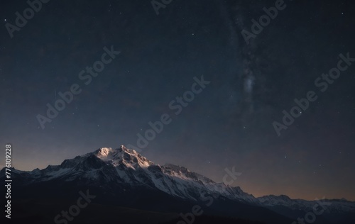 Snowcovered mountain under starry sky at night in natural landscape