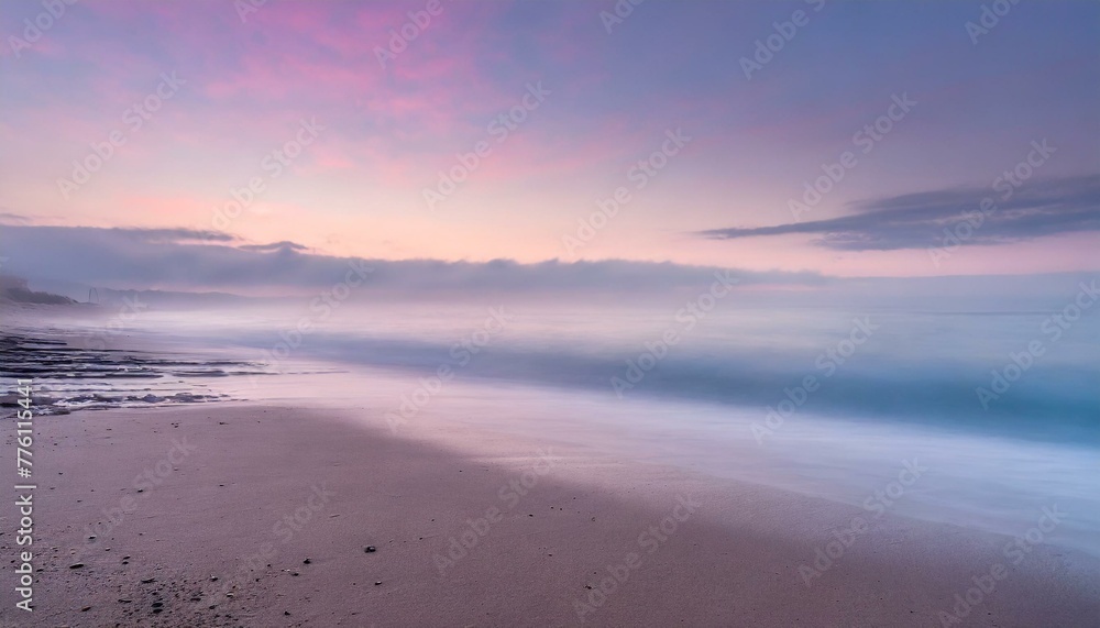 Beach in pink tones with fog coming down on horizon