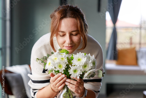 Young beautiful woman enjoying the smell of fresh flowers