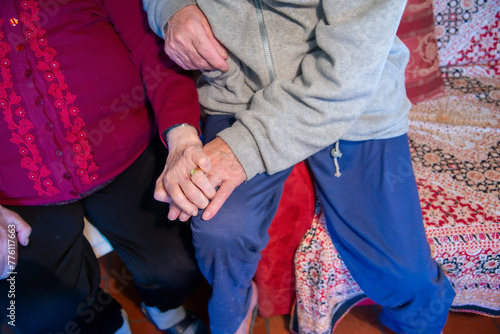 Two elderly seniors hand in hand at home