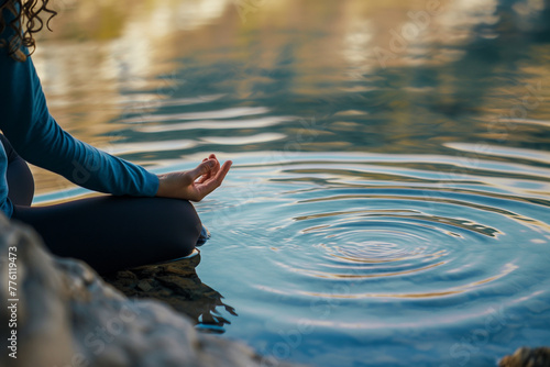 A close-up of a person meditating by a tranquil lake  with ripples of calm water reflecting the peacefulness of their inner state