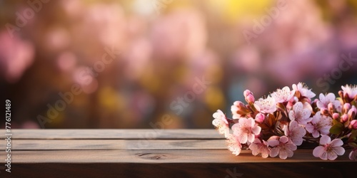 Spring and gardening background with flowering pink apple branches border and empty wooden table. Image for display your product.