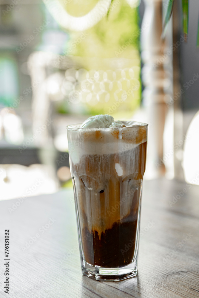 Iced coffee with whipped cream in a glass on a wooden table Iced coffee with whipped cream in a glass on a wooden table