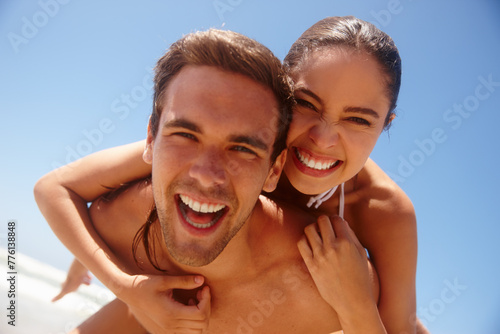 Happy, portrait and couple piggy back at the beach with love, hug and support together on holiday in summer. Laugh, sea and vacation with smile and bonding by water with travel in Miami with people