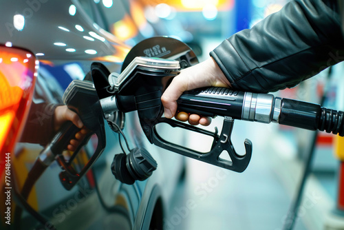 a close up image of a hand filling up a car with gas at a gas station photo