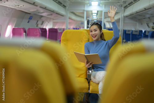 A woman is sitting on a yellow seat with a book in her lap