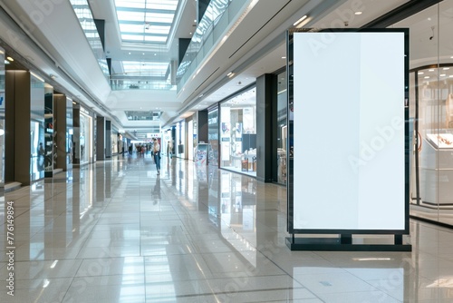 An indoor advertising display with a white mockup screen in a shopping mall