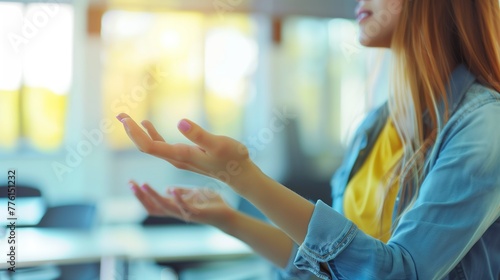 A close-up of a young female teacher's hands gesturing while she teaches in a bright and airy classroom © LaxmiOwl