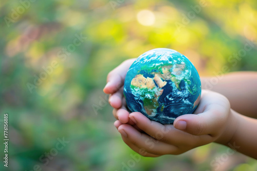 hands hold a miniature Earth nature blured background