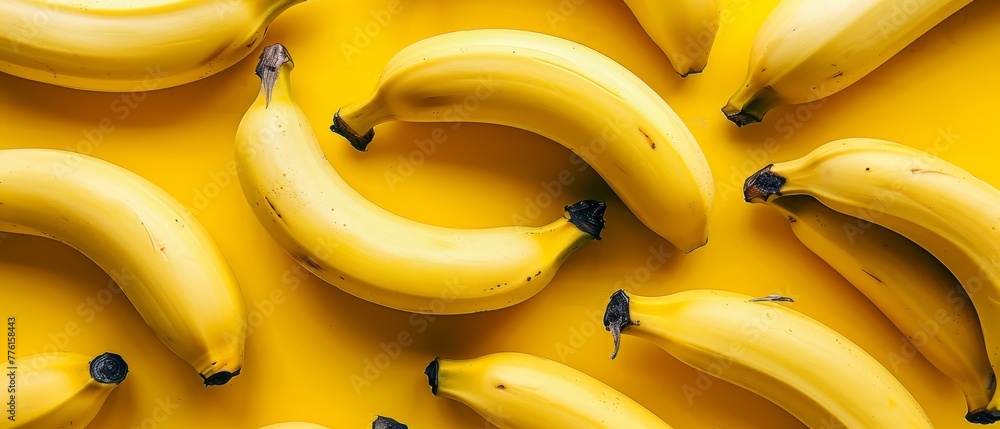 A bunch of ripe bananas sits atop a yellow counter, nearby rests an uncooked batch of unripe bananas A bunch of ripe bananas sits atop a yellow counter, nearby rests an uncooked batch of unripe bananas