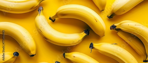   A bunch of ripe bananas sits atop a yellow counter, nearby rests an uncooked batch of unripe bananas