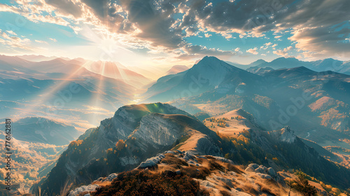 A panoramic view of a mountain range with a sun shining on the peaks