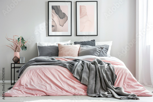 Grey blanket on pink bed against the wall with poster in modern bedroom interior. © Hunman