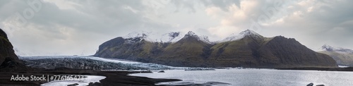 Skaftafellsjökull glacier, Iceland. Glacier tongue slides from the Vatnajökull icecap or Vatna Glacier near subglacial Esjufjöll volcano. Glacial lagoon with ice blocks and surrounding mountains. © wildman
