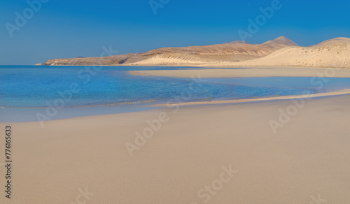 View of the coast of the Atlantic Ocean and the volcanic mountains peaks on a sunny day in Risco Del Paso -  Fuerteventura Island