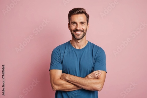 Smiling man with arms crossed standing by pink background