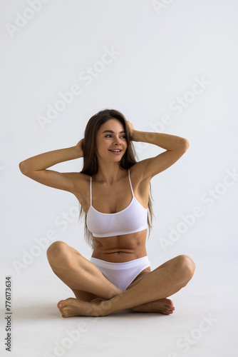 Woman with perfect figure in grey underwear lying on floor over gray studio background. © F8  \ Suport Ukraine