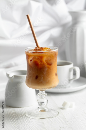 Iced coffee with cream and cup of black coffee.