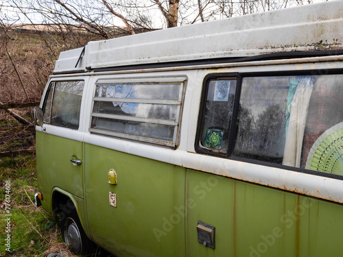 close up of old green painted classic camper motor home with white pop top roof