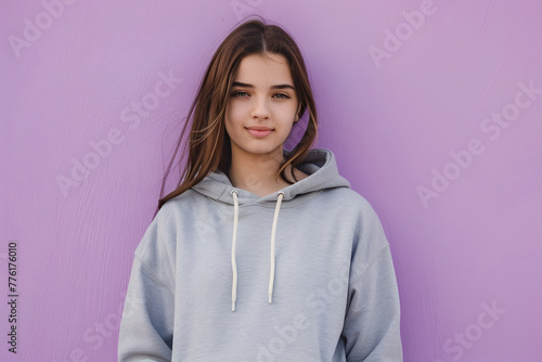 Young woman in gray hoodie on purple background © MAKSIM MAKSIMOV