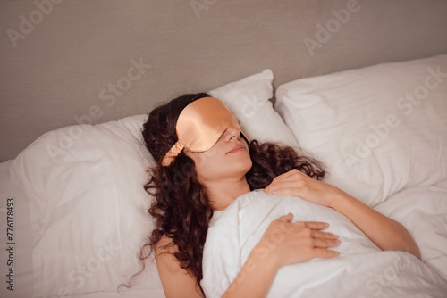 woman in beige silk sleep mask rest in bed at home. deeper and more restful sleep by blocking out any unwanted light