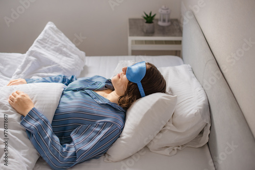 woman is fast asleep in bed. sleep mask against insomnia concept