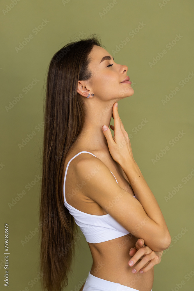 Smiling young woman n white underwear with perfect fit body standing posing raise up hands isolated on green background Smiling young woman n white underwear with perfect fit body standing posing raise up hands isolated on green background