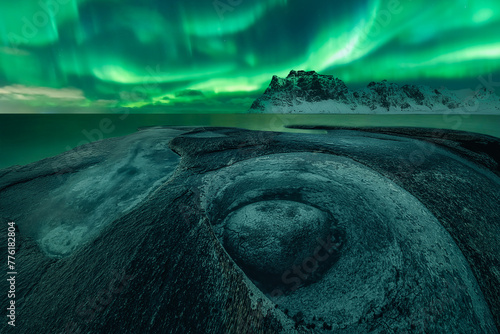 Northern Lights in Uttakleiv beach over the rock formation known as The Dragon's Eye (low angle view), Uttakleiv beach, Lofoten and Vesteral Islands, Nordland, Northern Norway, Norway
 photo