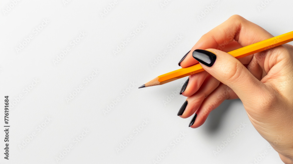 A close-up view of a person's hand elegantly positioned as it grips a standard yellow pencil, poised to write A close-up view of a person's hand elegantly positioned as it grips a standard yellow pencil, poised to write