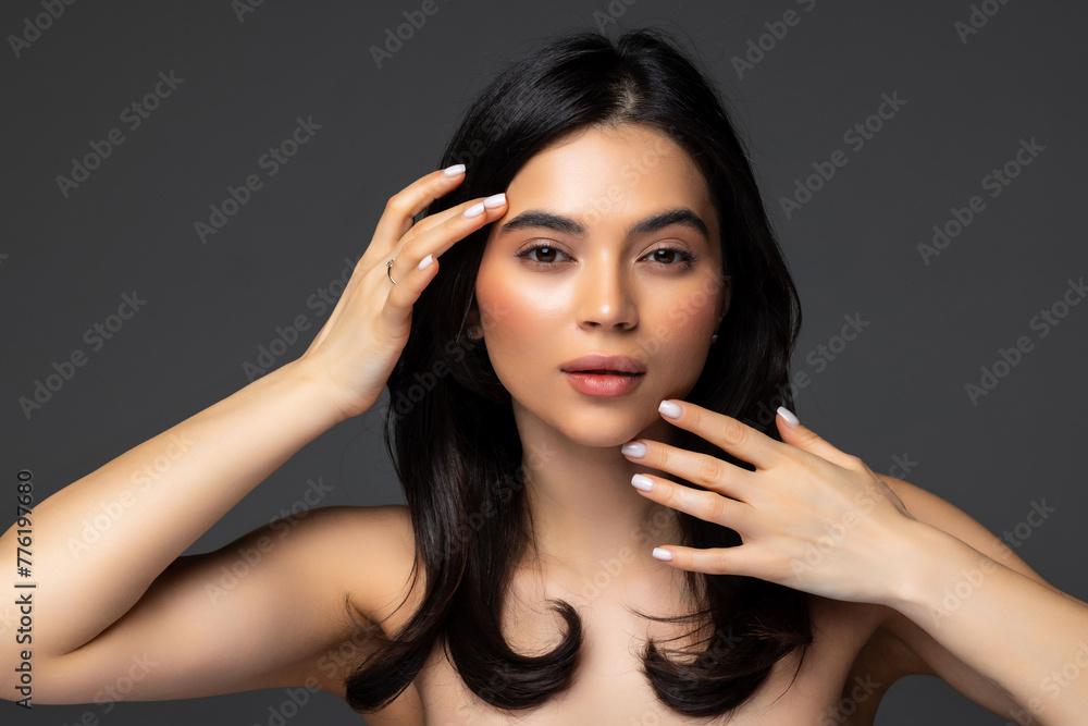 Fototapeta premium Close-up of an attractive woman wearing turtleneck sweater while sitting at isolated dark background.