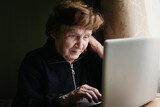 An old woman learning how to use a computer.