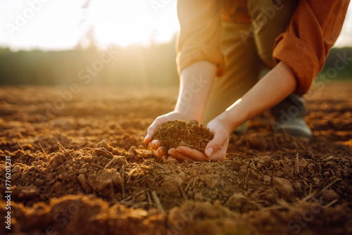 Women's hands sort through fertile soil in the field. Farmer checks the quality of the soil. Gardening season. Ecology, agriculture concept.