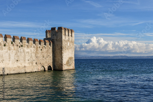 Crenellated walls of the dockyard of the Scaliger Castle, one of the better preserved castles of Italy and rare example of lake fortification, Sirmione, Brescia, Lombardy, Italy