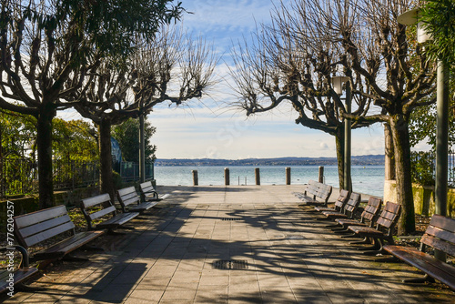 Rows of benches on the lakeside of Lake Garda in winter, Sirmione, Brescia, Lombardy, Italy