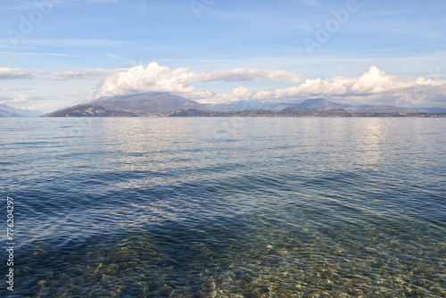 Transparent water of Lake Garda with the alpine range of Monte Baldo in the background, Sirmione, Brescia, Lombardy, Italy