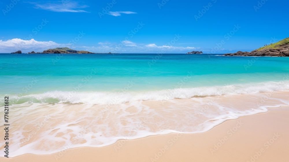 Pristine waters and sandy beach with blue sky in the background