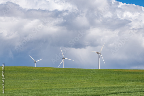 Turbines in a mountain wind farm. Rapeseed and windwheels. Ecological energy production. photo